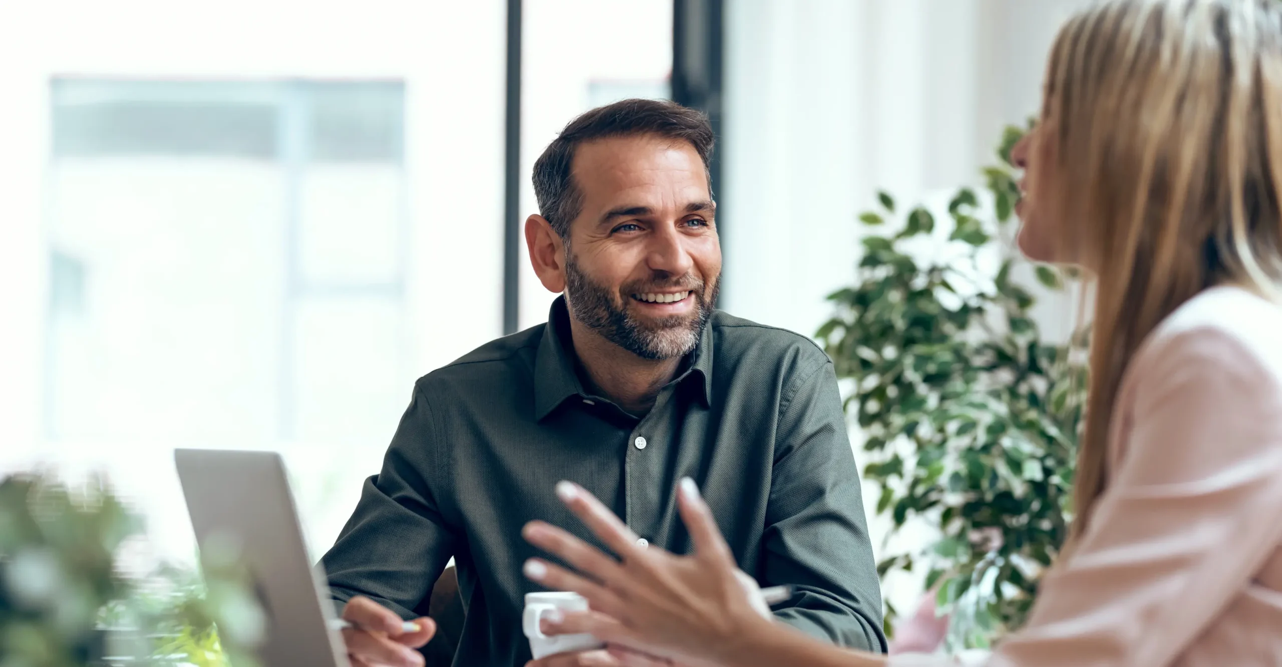 A man happily conversing during a meeting